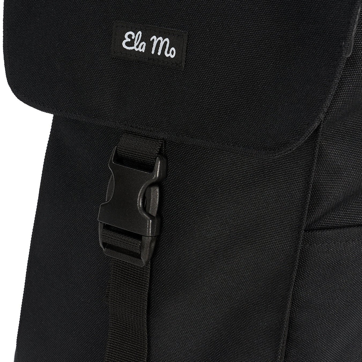 Ela Mo™ Everywhere Daypack | Black. Ein schwarzer Rucksack mit geschlossenem Klickverschluss an der Vorderseite.