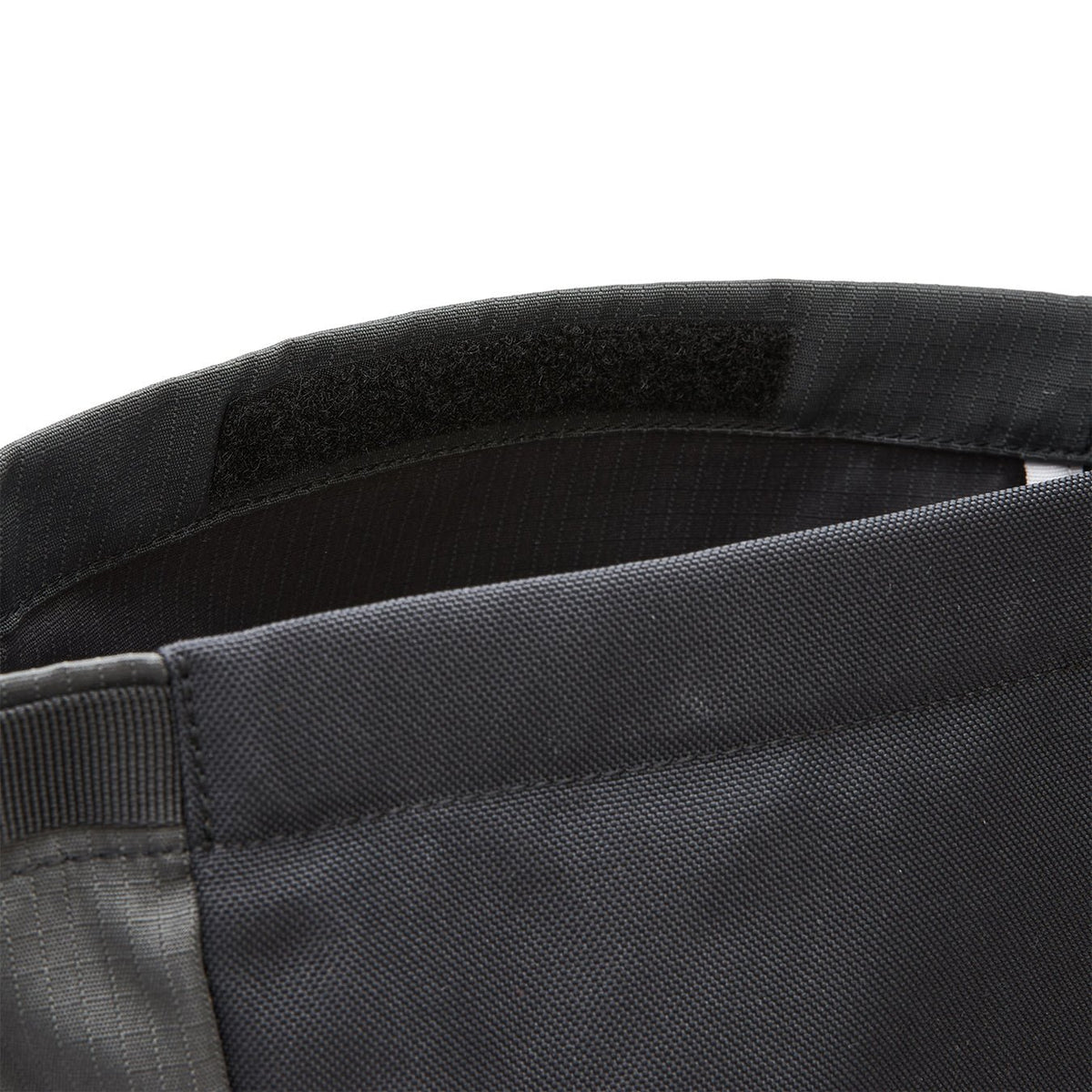 Ela Mo™ Rolltop Lite | Black. Klettverschluss an einem schwarzen Rucksack.