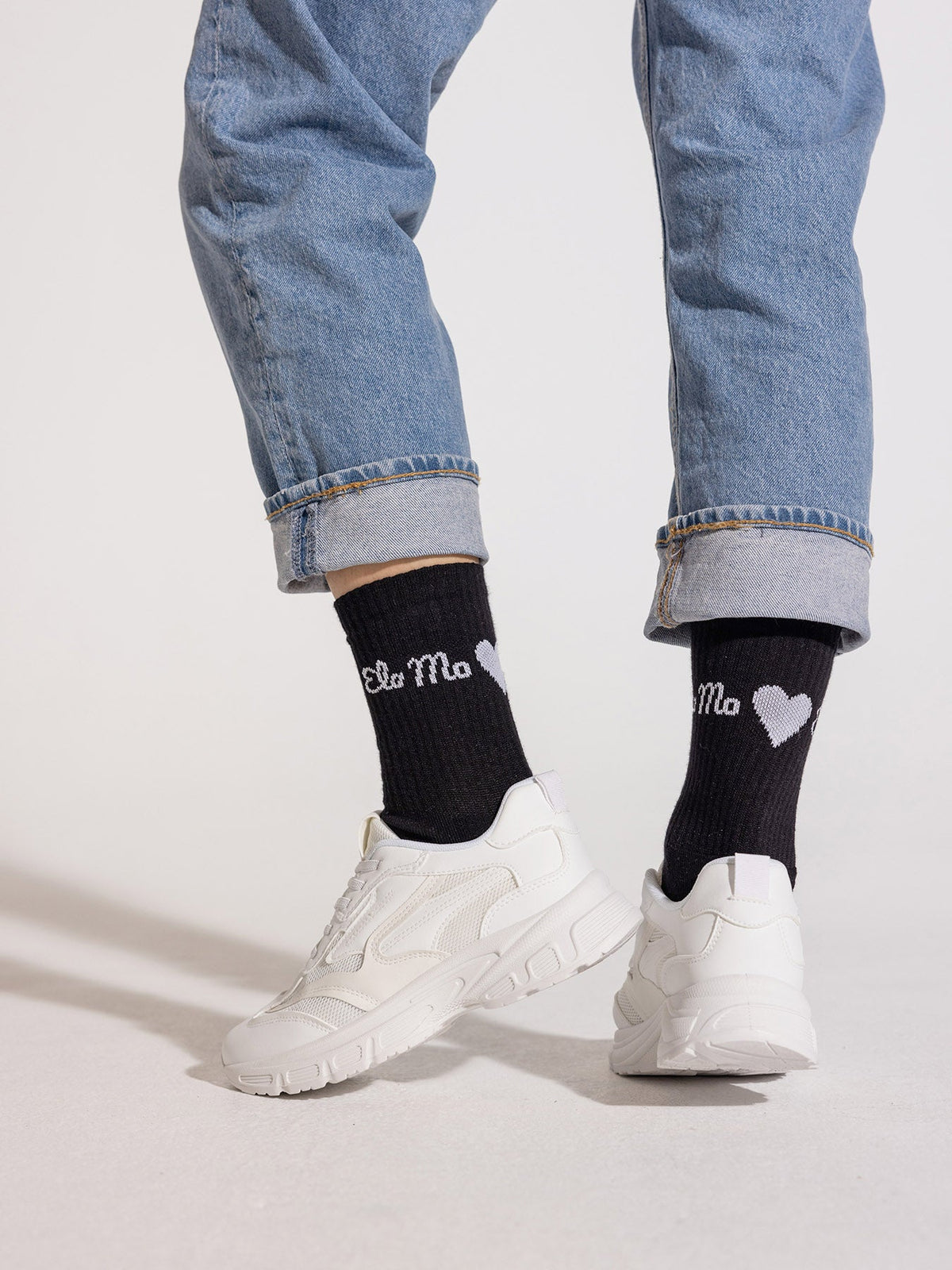 Ela Mo™ Socken aus Bio-Baumwolle-Eine Person in schwarzen Ema-Mo-Socken, Jeans und Sneakers – ein stylisches Alltagsoutfit.
