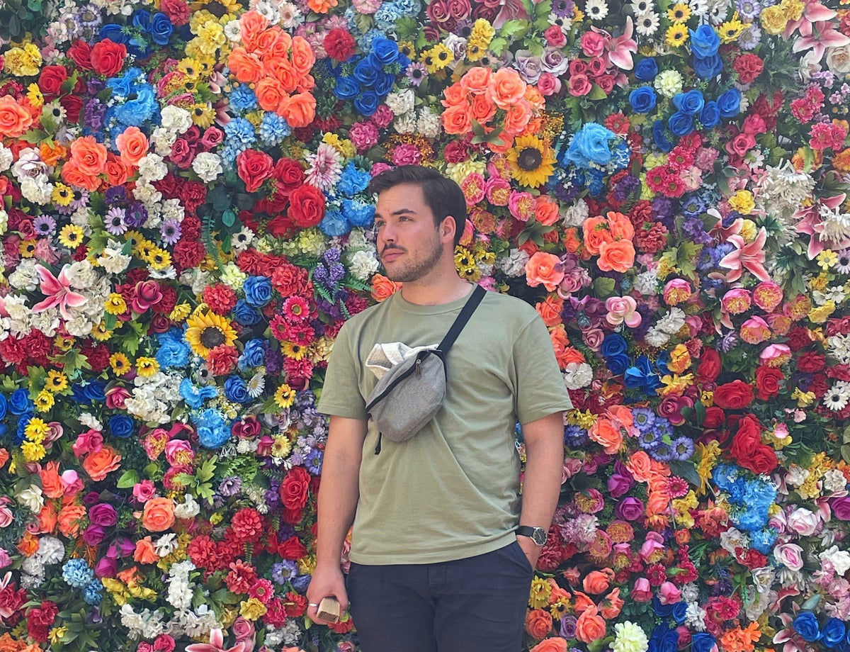 Florian Hohndorf vor einer Wand, die mit Blumen bedeckt ist