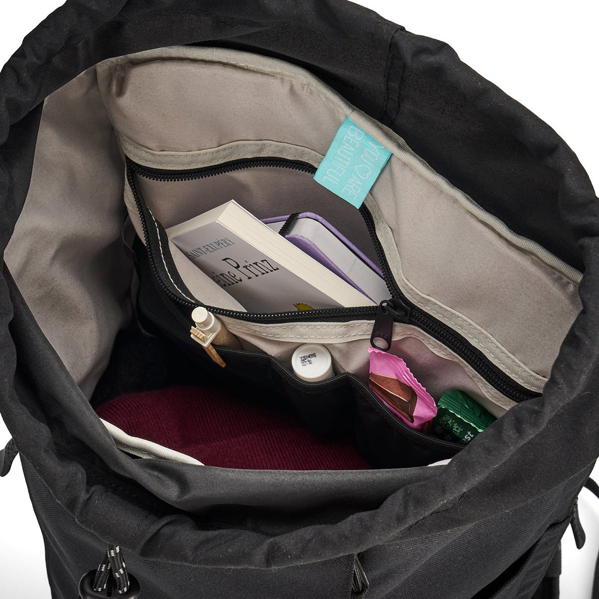Ela Mo™ Everywhere Daypack | Grape. Innenbereich des Rucksacks mit vielen Fächern und alltäglichen Gegenständen.