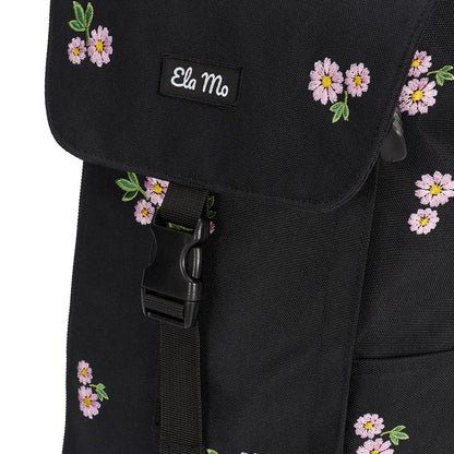 Ela Mo™ Everywhere Daypack | Embroidery Edition Upsy Daisy. Vorderseite des schwarz geblümten Rucksacks mit Schnalle.
