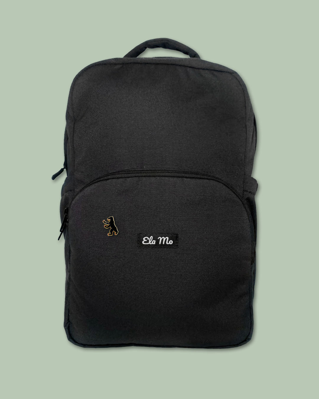 Ela Mo™ Pin für Rucksäcke – Berlin | Auf schwarzem Rucksack vor hellgrünem Hintergrund