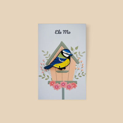 Ela Mo™ Pin für Rucksäcke - Meise vor einem Vogelhaus