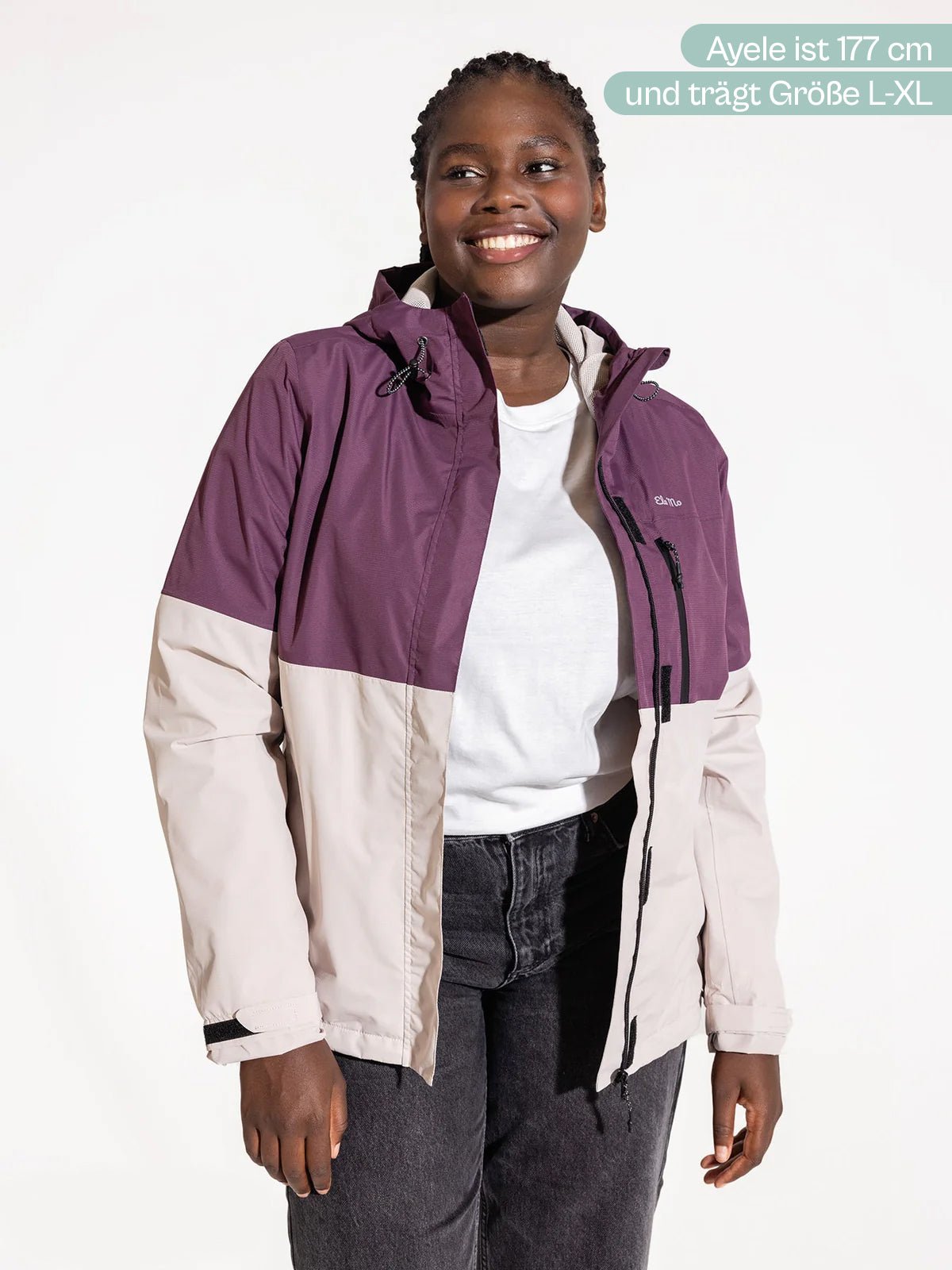 Ela Mo™ Regenjacke | Grape. Die Regenjacke in Rosa- und Lilatönen – eine Frau präsentiert die Größenangaben.