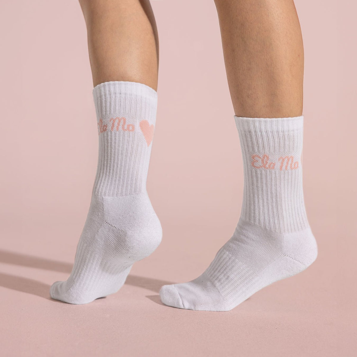 Ela Mo™ Socken aus Bio-Baumwolle-Eine Person in weißen Socken mit dem Herstellerlogo ‚Ela Mo‘ und einem kleinen Herz darauf.