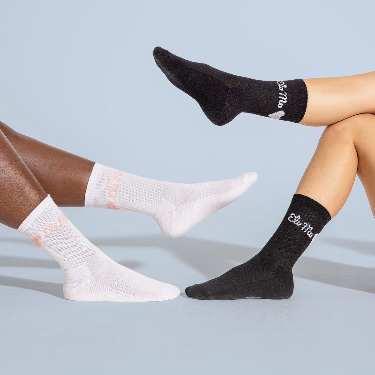 Ela Mo™ Socken aus Bio-Baumwolle-Personen mit schwarzen und weißen Socken, die mit dem Herstellerlogo ‚Ema Mo‘ versehen sind