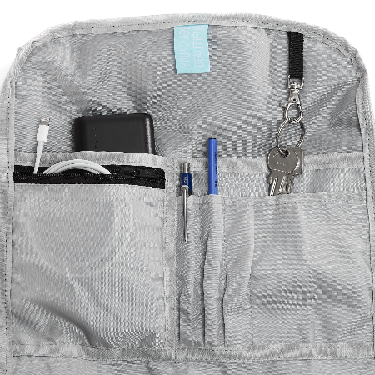 Ela Mo™ Rolltop Rucksack Night Edition | Peach. Hellgrauer Innenbereich des Rucksacks mit Fächern und Alltagsgegenständen.